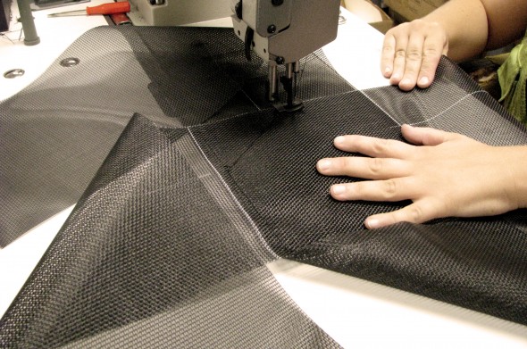A Mountain employee stitching a custom chain bag